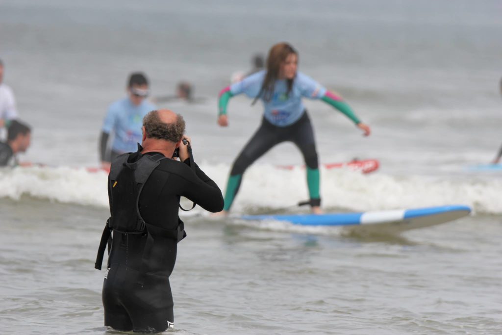 Patrick avec son appareil photo en train de prendre en photo Lou sur une vague  
lors d'une journée See Surf  