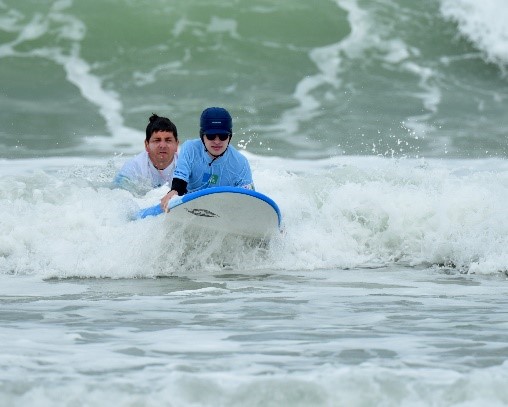 Un bénévole qui fait surfer un see surfeur. 